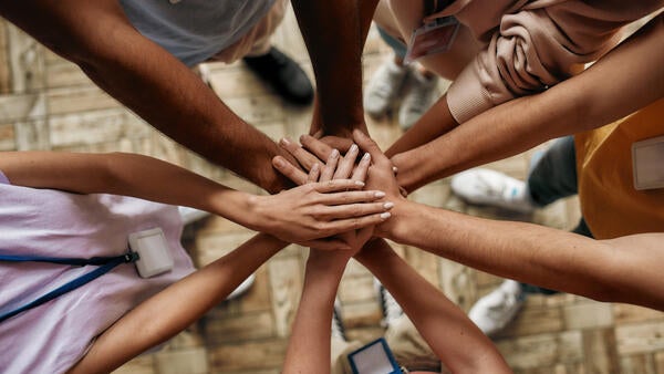 People with their hands stacked