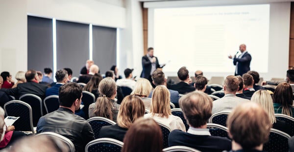 A presenter in front of a crowd